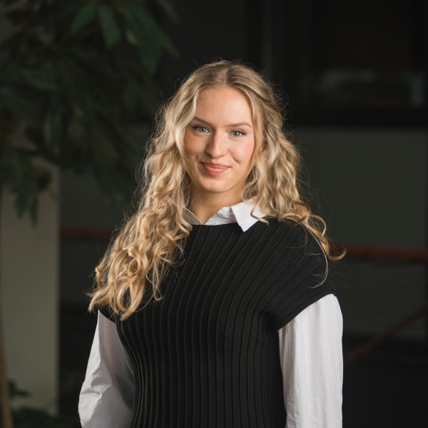 Medewerker in een zwarte spencer over een wit overhemd